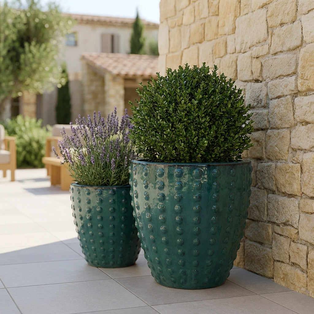 Detail na ručně vyráběný keramický květináč Attila v petrolejově modré barvě. Glazovaný terakotový květináč s reliéfní texturou a zasazenou levandulí na slunné kamenné terase.