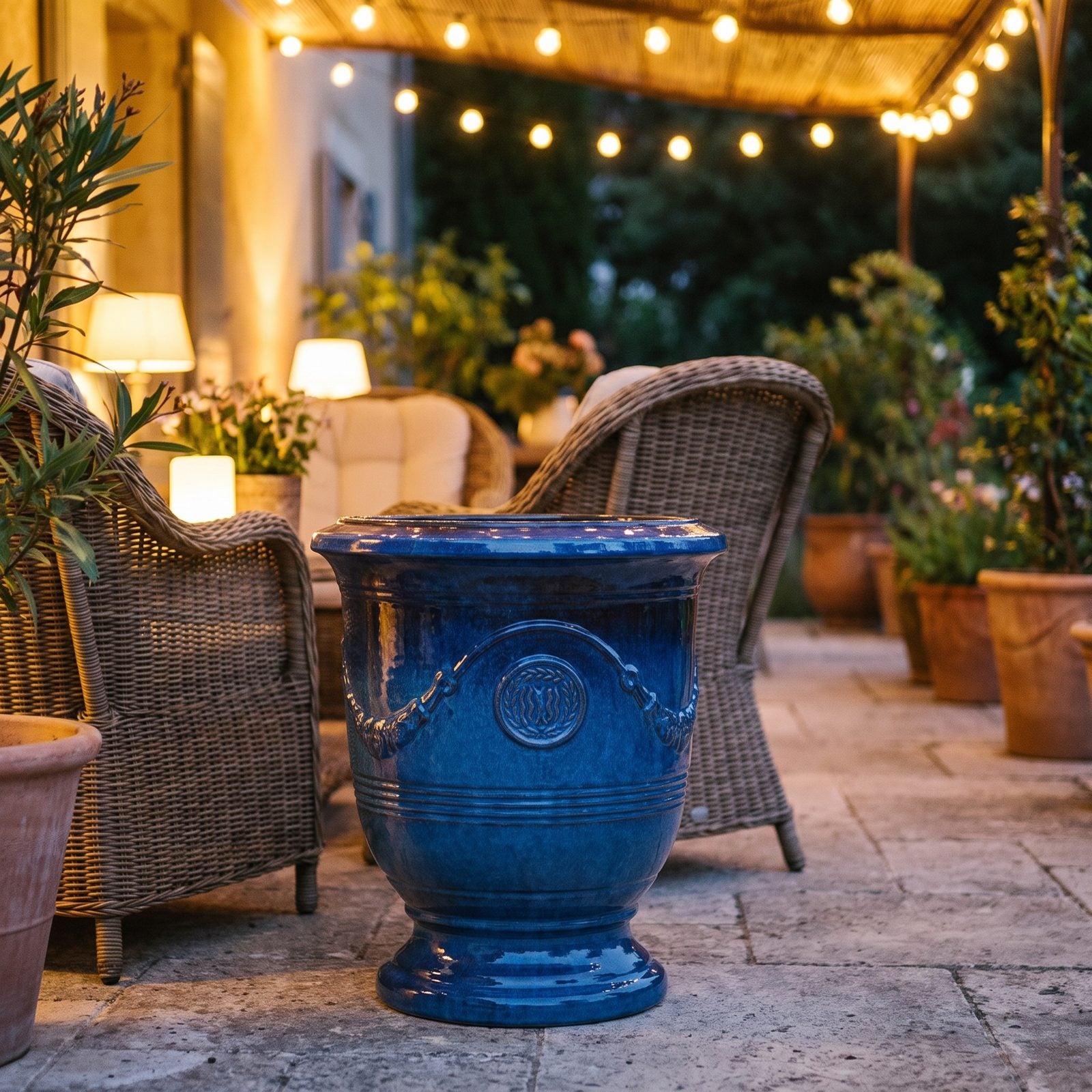 Abendliche Terrasse mit Lampen und Pflanzkübeln RICHELIEU Azurblau mit Blick auf die Bucht