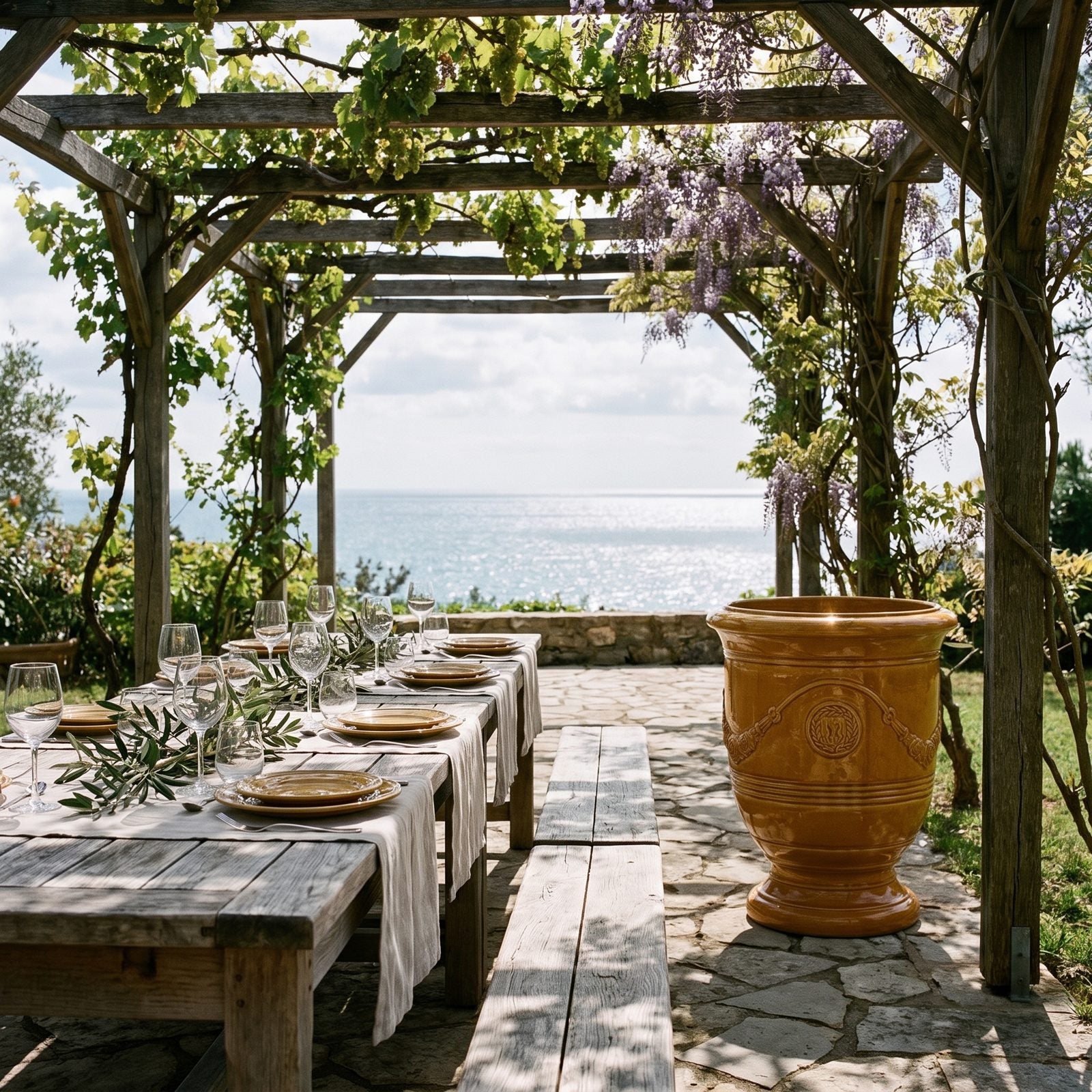 Gedeckter Tisch unter der Pergola mit Meerblick, flankiert von zwei RICHELIEU Honig