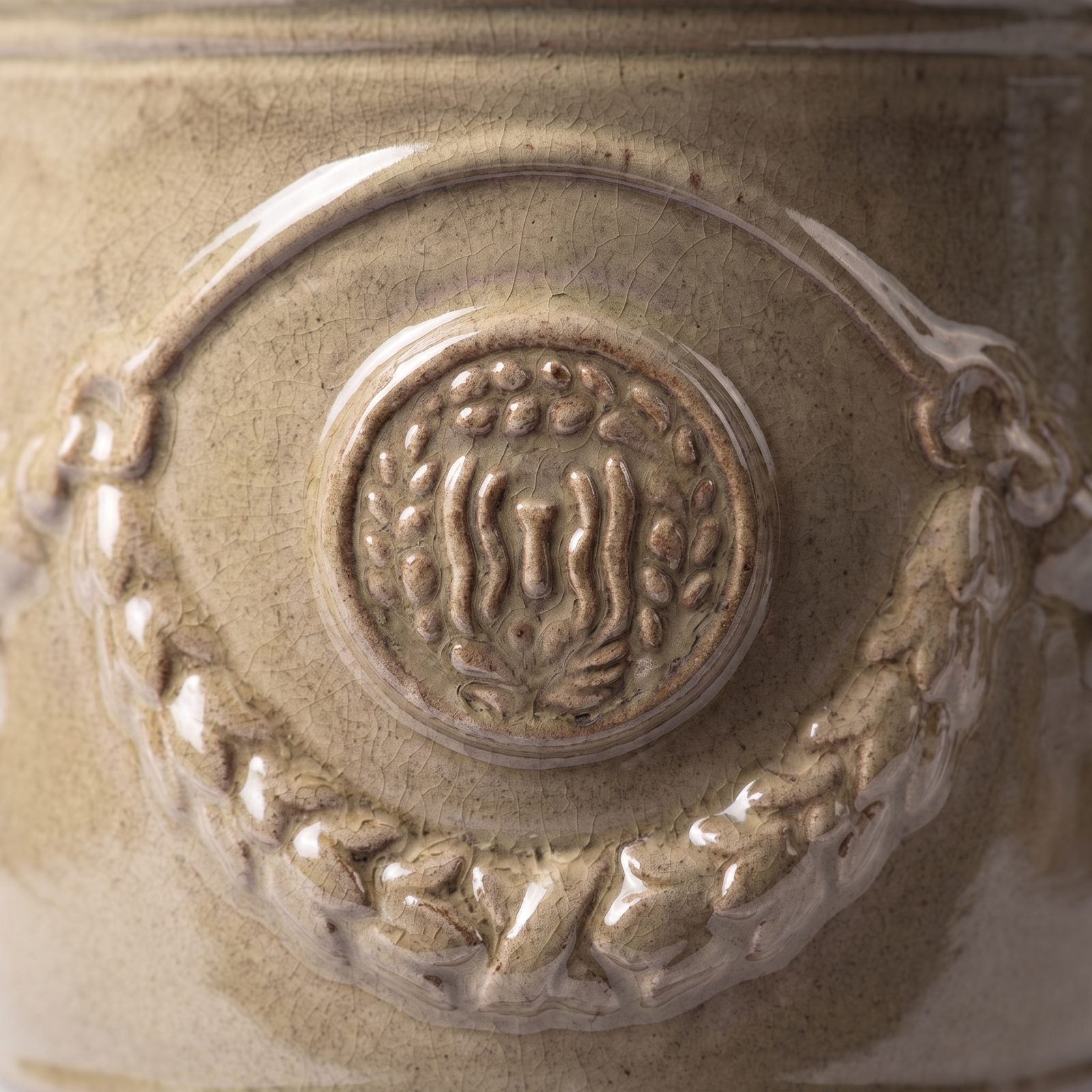Detail der Glasur Sandbronze auf Girlande und Siegel des Pflanzkübels RICHELIEU